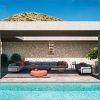 Bộ sofa sân vườn hiện đại khung nhôm, nệm xám, phối gối màu cam, đặt cạnh hồ bơi sang trọng