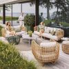 Bộ sofa sân vườn giả mây hiện đại gồm sofa đôi, 2 ghế đơn, bàn trà kính, nệm ghi, bối cảnh ngoài trời sang trọng