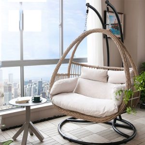 Xích đu đôi giả mây khung sắt nệm màu kem đặt trong phòng khách view thành phố