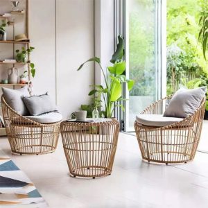 Hai ghế đơn và bàn trà giả mây đặt trong không gian xanh mát, phong cách Bắc Âu