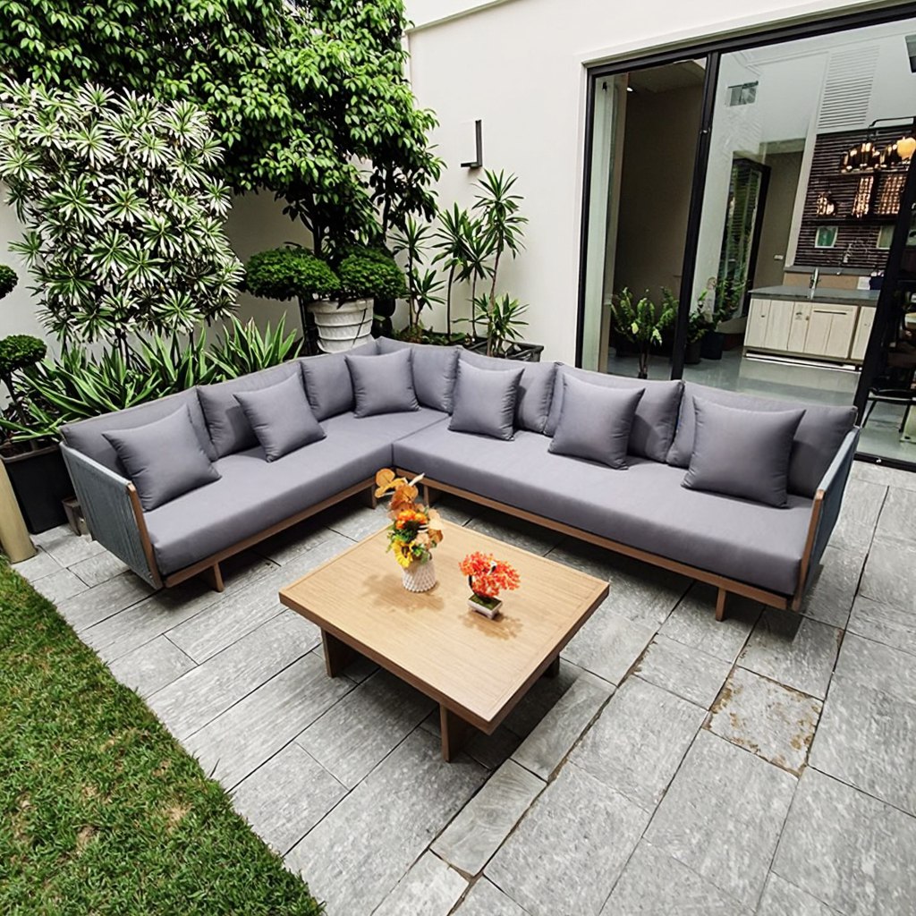Sofa ngoài trời góc L lớn, nệm dày màu ghi, bàn trà gỗ vuông, phù hợp sân vườn xanh mát