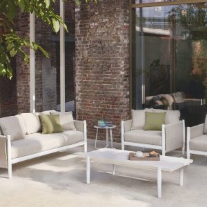 Bộ sofa ngoài trời 4 món, phối cảnh sân vườn, khung trắng, nệm ghi, gối xanh rêu nổi bật