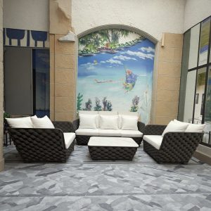Bộ sofa ngoài trời 4 món, đan dây bản lớn, nệm trắng, bối cảnh trong nhà với tranh tường biển