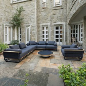 Bộ sofa ngoài trời hiện đại trong sân biệt thự, nệm xám đậm, bàn trà tròn đồng bộ