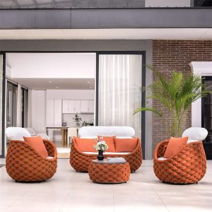 Bộ ghế sofa ngoài trời dây rope nâu cam, nệm trắng kem, bối cảnh sân vườn sang trọng