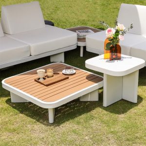 Cận cảnh bàn trà vuông mặt gỗ nhựa ngoài trời, phối cùng sofa sân vườn nệm trắng kem.