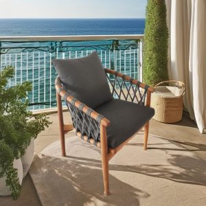Ghế ngoài trời hiện đại đặt trên ban công view biển, nệm và gối tựa màu xám