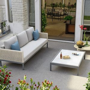 Sofa sân vườn dài 3 chỗ, bàn trà mặt kính, nệm xám, gối xanh dương đặt ngoài trời sang trọng