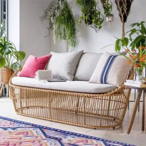 Sofa đôi giả mây với nệm và gối tựa màu ghi, trang trí nhiều cây xanh