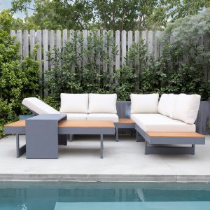 Bộ sofa nhôm sơn tĩnh điện, mặt gỗ teak, nệm trắng kem đặt cạnh hàng rào gỗ ngoài trời