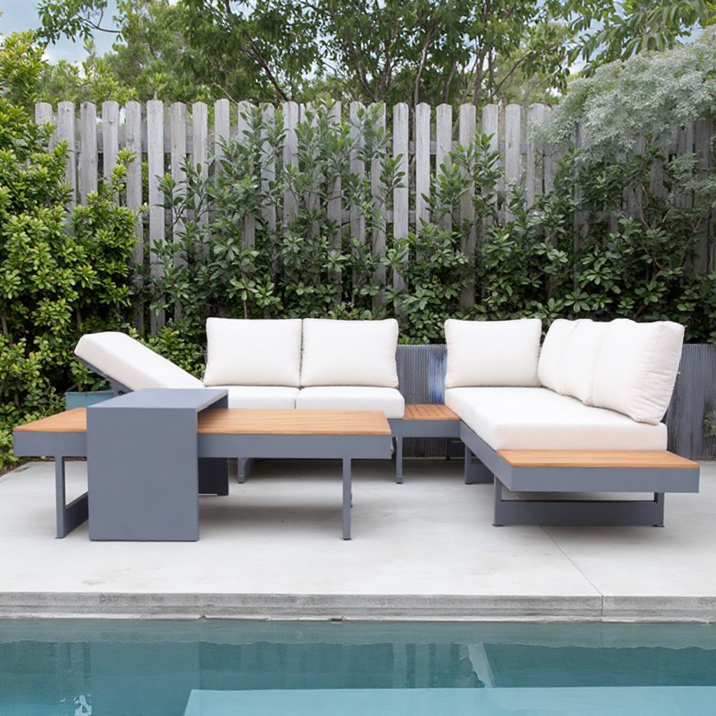 Bộ sofa nhôm sơn tĩnh điện, mặt gỗ teak, nệm trắng kem đặt cạnh hàng rào gỗ ngoài trời