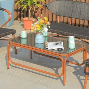 Cận cảnh bàn trà kính cường lực khung nhôm giả gỗ, trang trí hoa và tách trà