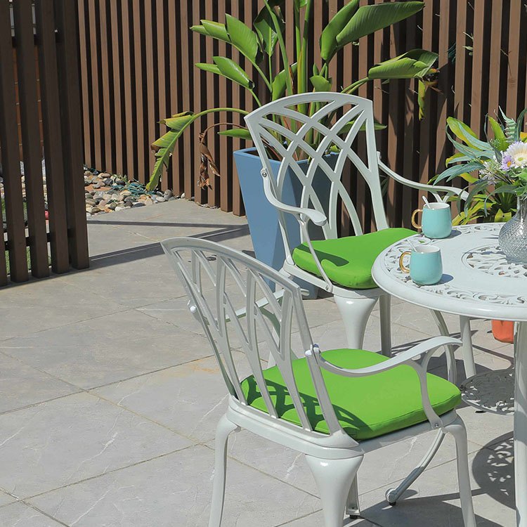 Cận cảnh ghế nhôm đúc lưng đan hoa văn hiện đại, nệm ngồi xanh lá
