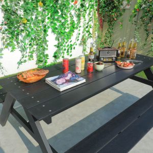 Cận cảnh mặt bàn nhựa giả gỗ màu đen, bày đồ ăn uống ngoài trời