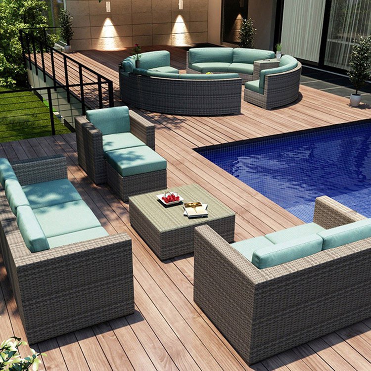 Bộ sofa giả mây ngoài trời màu xám, nệm xanh nhạt, đặt cạnh hồ bơi, không gian sang trọng