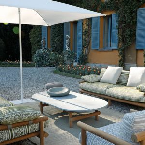 Cận cảnh bàn trà mặt đá và sofa dài ngoài trời, nệm vải họa tiết xanh lá sang trọng