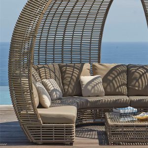 Cận cảnh sofa góc ngoài trời mái vòm, nệm dày màu be, view biển