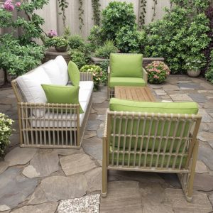 Sofa sân vườn 4 món, khung giả mây, nệm xanh trắng, đặt trong khu vườn nhiều hoa lá