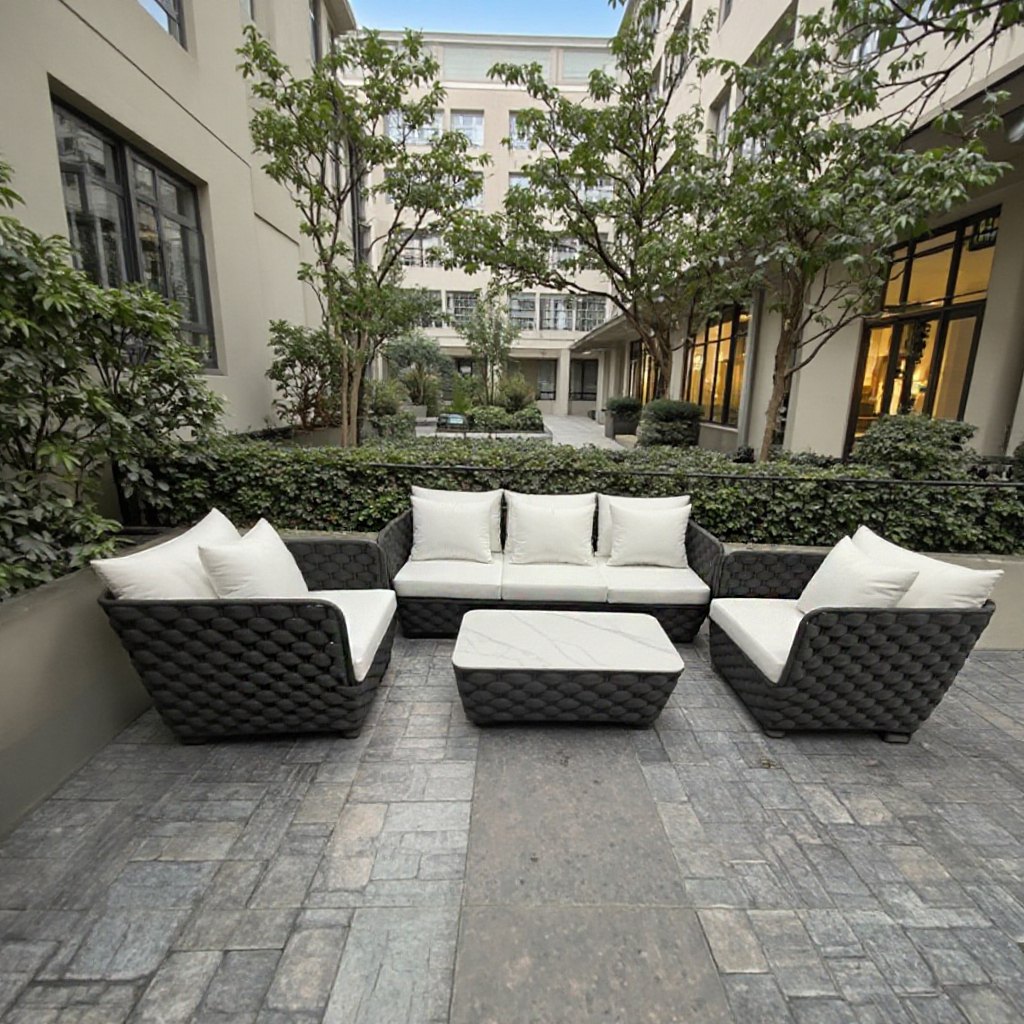 Bộ sofa sân vườn hiện đại, đan dây thủ công, nệm trắng, đặt ở sân nội khu chung cư
