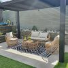Bộ sofa giả mây 4 món đặt ngoài trời dưới mái che, phối cảnh sân vườn sang trọng