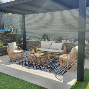 Bộ sofa giả mây 4 món đặt ngoài trời dưới mái che, phối cảnh sân vườn sang trọng