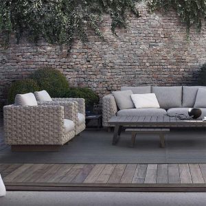 Bộ sofa ngoài trời đan rope, nệm dày, bàn trà mặt gỗ, bối cảnh sân vườn tường gạch cổ điển.
