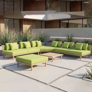 Bộ sofa sân vườn góc L màu xanh lá, kê ở sân biệt thự hiện đại, nổi bật với nệm dày và bàn trà nan