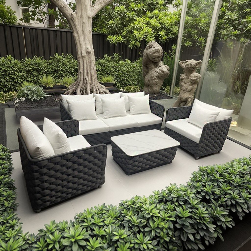 Bộ sofa ngoài trời 4 món, khung nhôm đan dây rope, nệm trắng, đặt cạnh cây xanh và tượng đá
