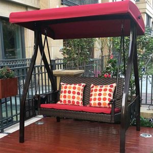 Xích đu sân vườn 2-3 chỗ, nệm đỏ, gối chấm bi đỏ trắng, mái che đỏ, đặt trên sàn gỗ ngoài trời