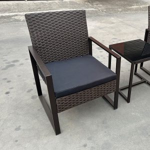 Cận cảnh ghế đơn giả mây khung sắt, nệm ngồi dày, bàn mặt kính ngoài trời